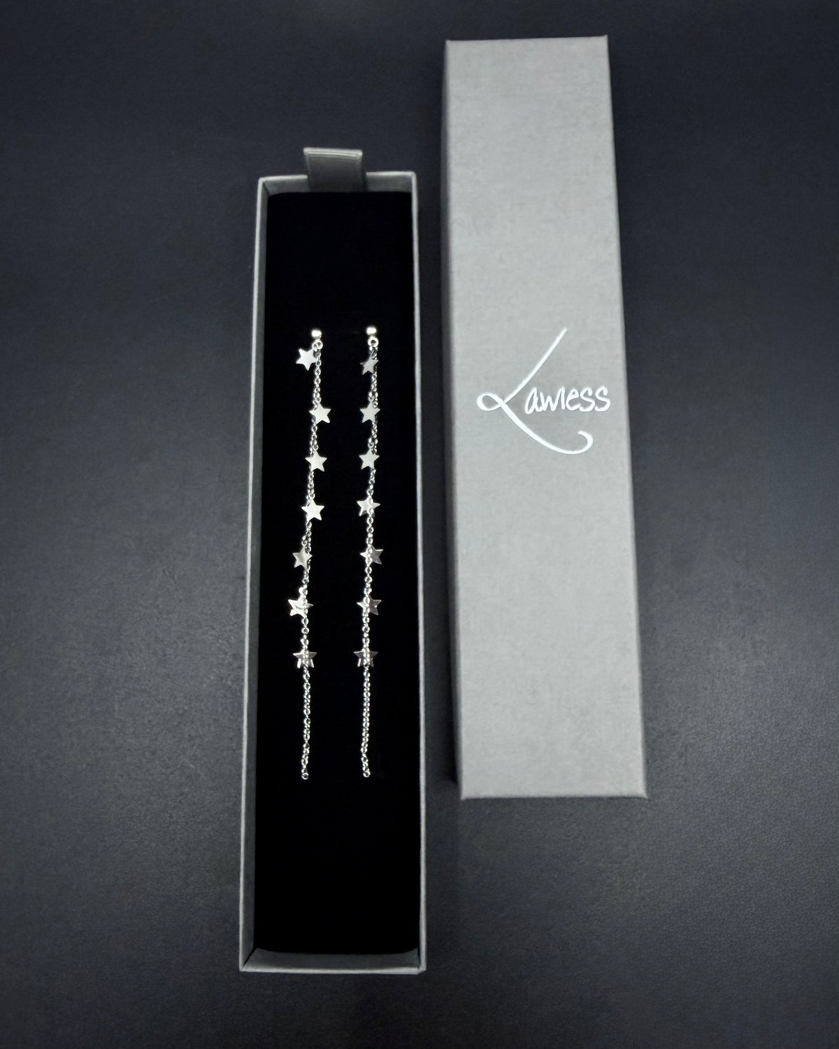 Long silver celestial drop earrings with multiple star charms on fine stainless steel chains, Urania Meridian Earrings by Lawless Jewellery