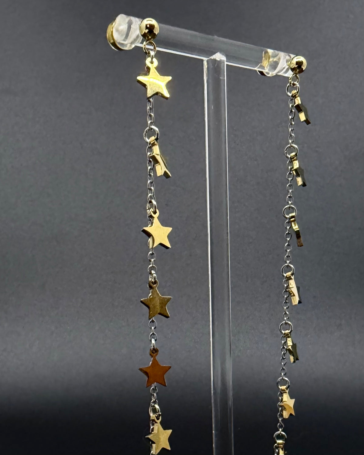 Long mixed-metal celestial drop earrings with gold star charms on silver stainless steel chains, Urania Meridian Earrings by Lawless Jewellery.