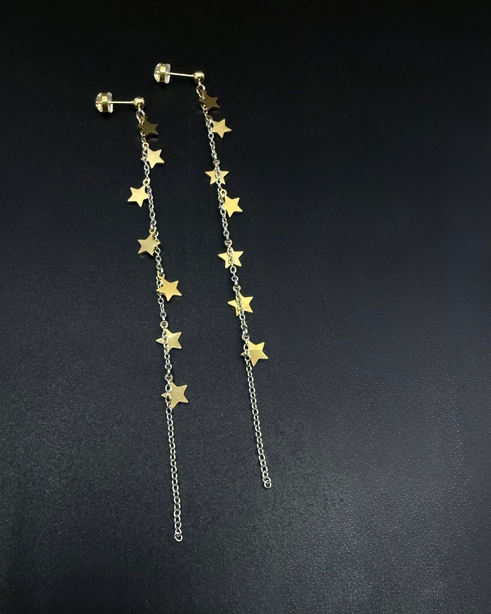 Long mixed-metal celestial drop earrings with gold star charms on silver stainless steel chains, Urania Meridian Earrings by Lawless Jewellery.