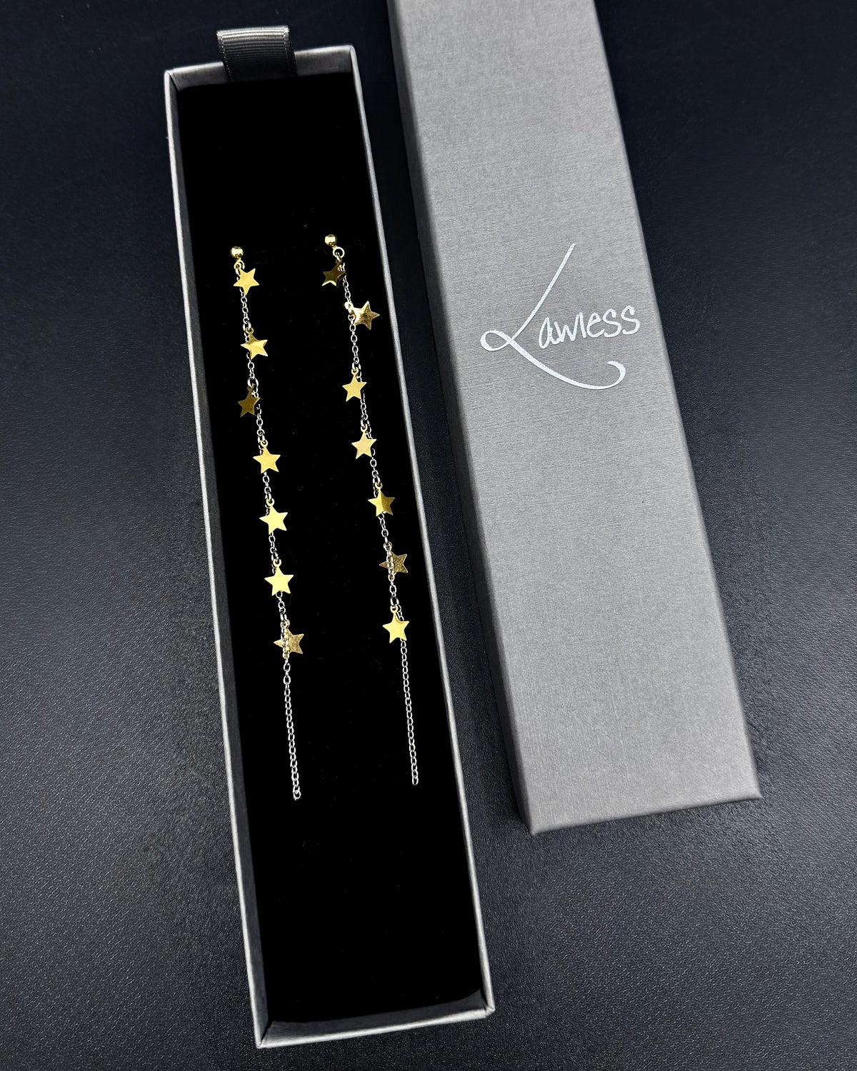 Long mixed-metal celestial drop earrings with gold star charms on silver stainless steel chains, Urania Meridian Earrings by Lawless Jewellery.