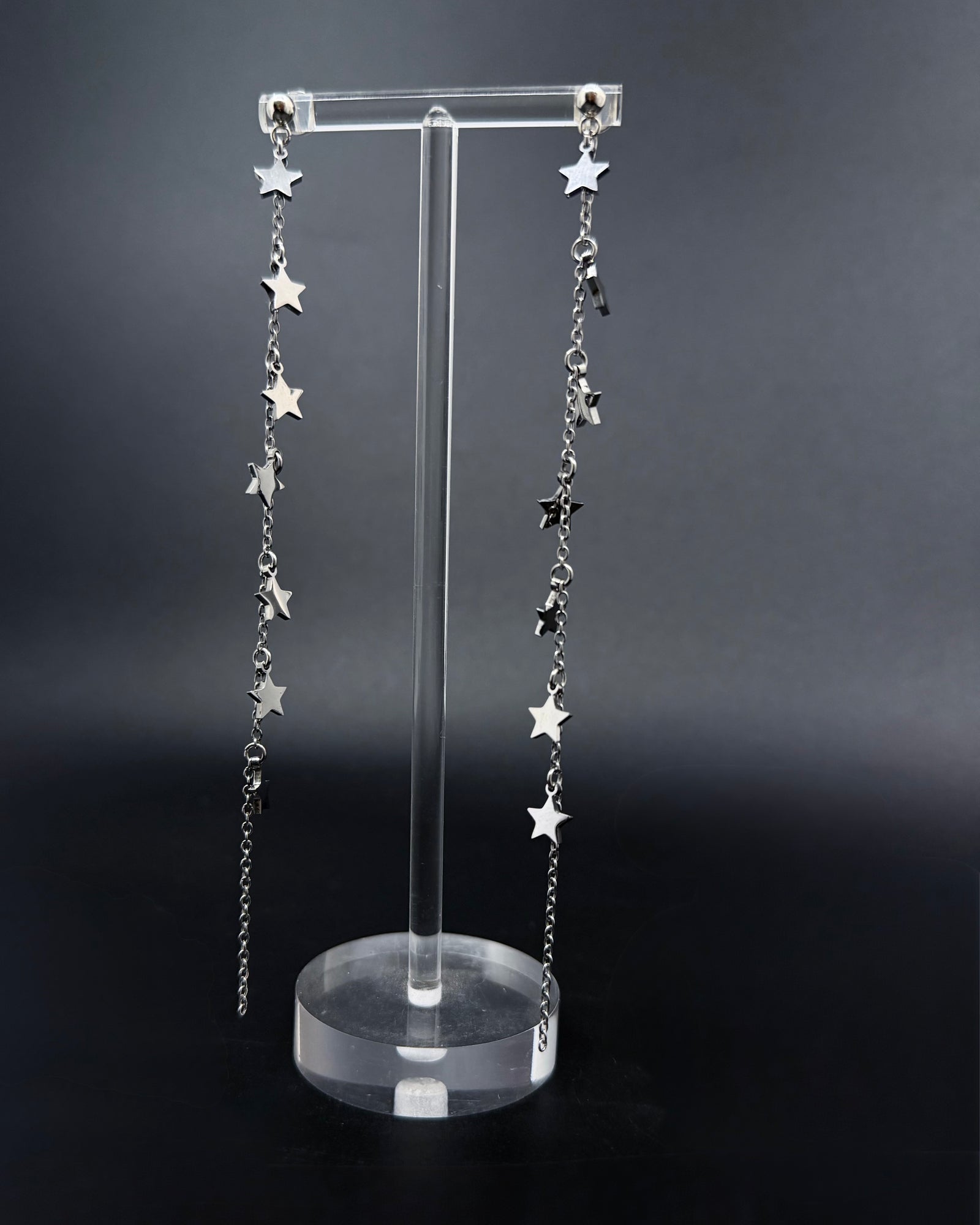 Long silver celestial drop earrings with multiple star charms on fine stainless steel chains, Urania Meridian Earrings by Lawless Jewellery