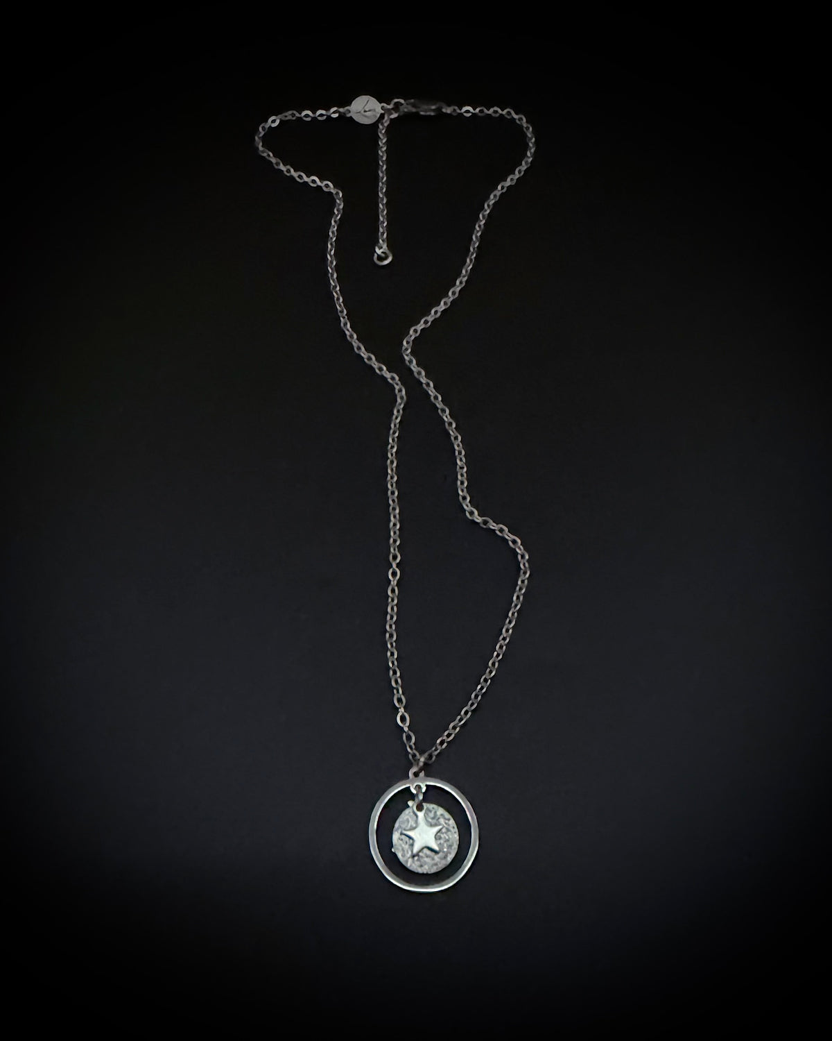 Silver reversible moon and star necklace with textured disc pendant and adjustable chain, Urania Collection by Lawless Jewellery.