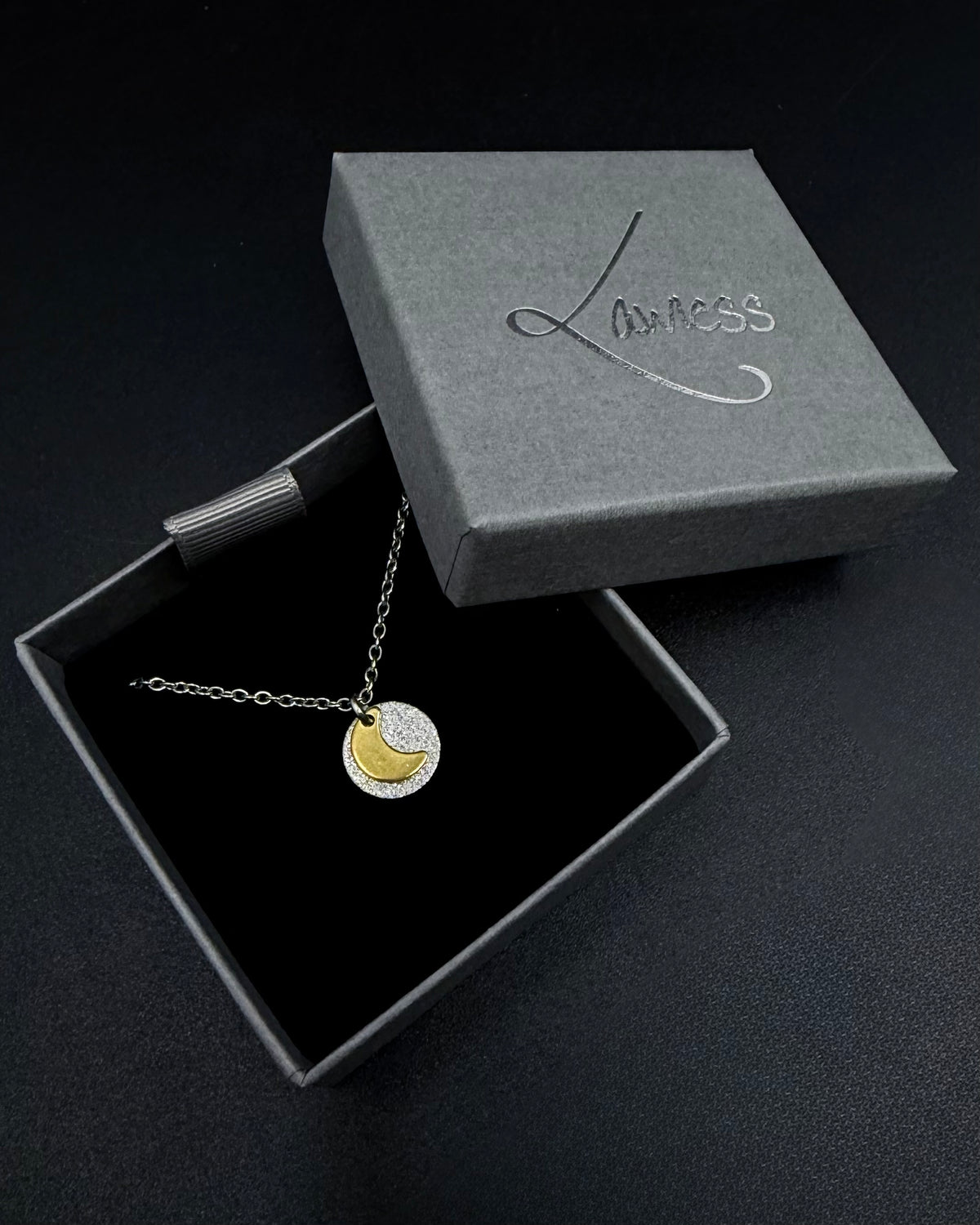 Mixed metal Urania Signal necklace with silver textured disc and gold crescent moon pendant on adjustable stainless steel chain.