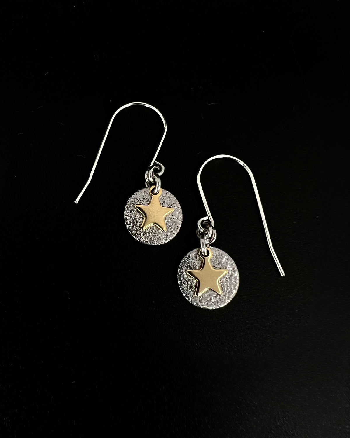 Silver and gold celestial star earrings with textured silver disc and polished gold star charm on stainless steel hooks