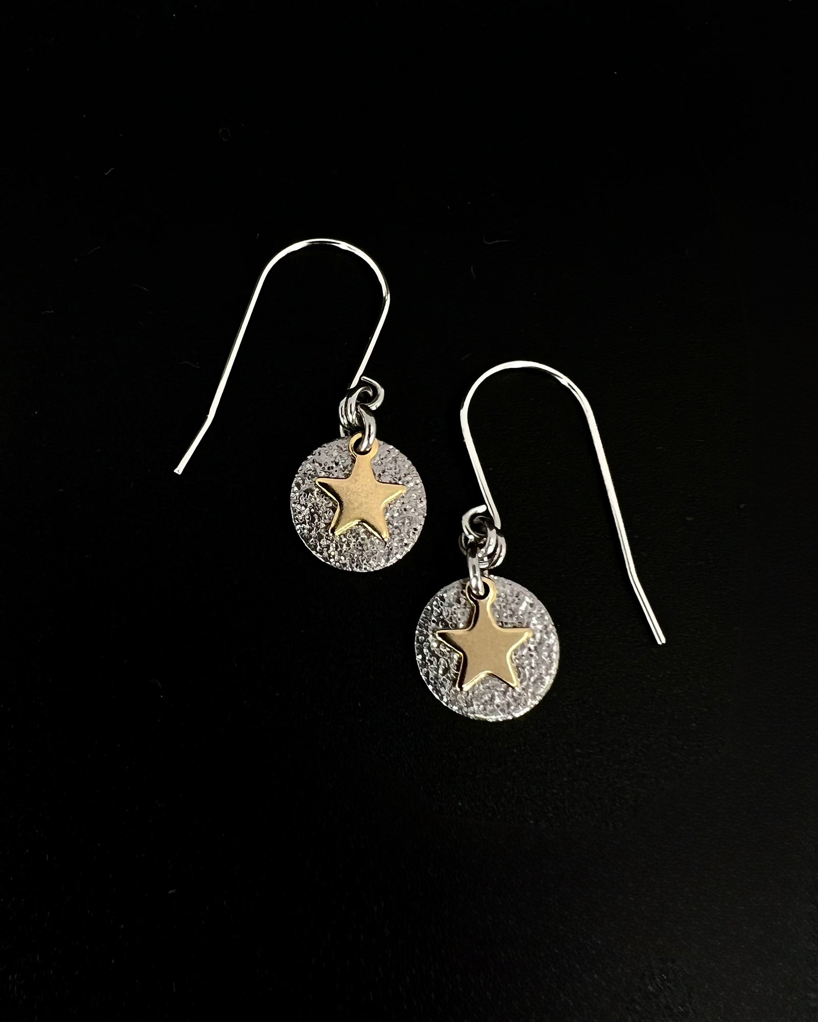 Silver and gold celestial star earrings with textured silver disc and polished gold star charm on stainless steel hooks