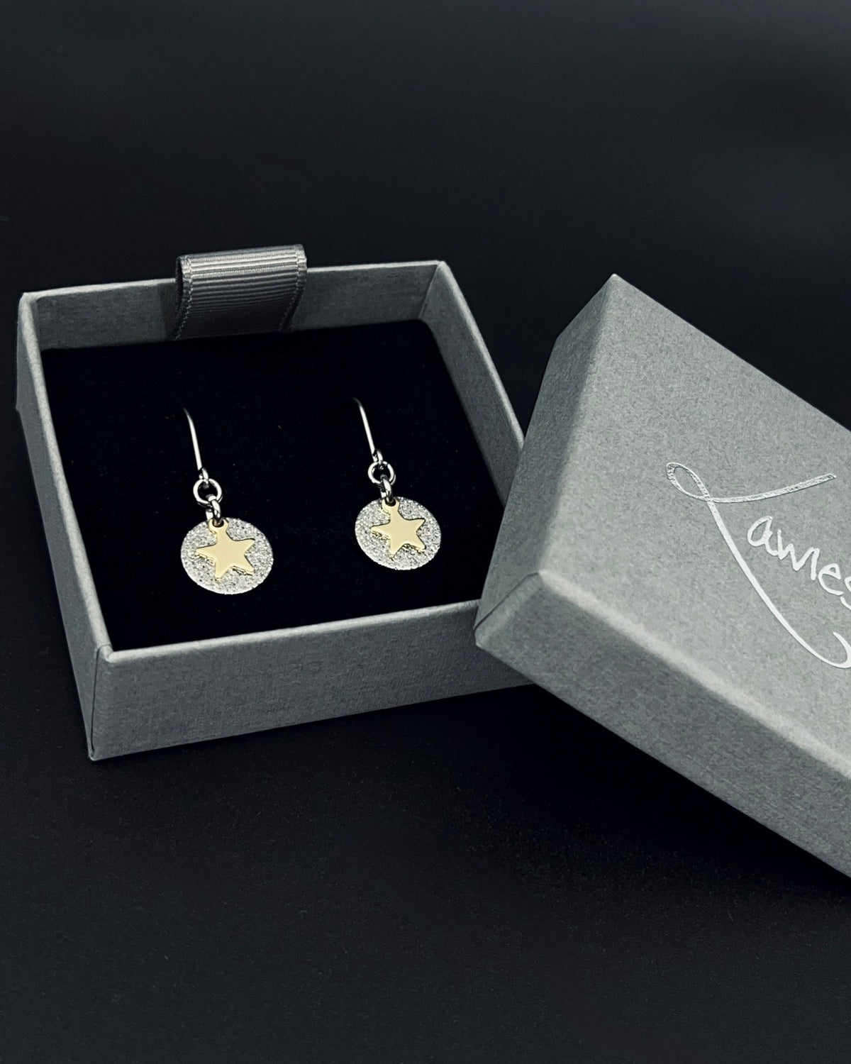 Silver and gold celestial star earrings with textured silver disc and polished gold star charm on stainless steel hooks