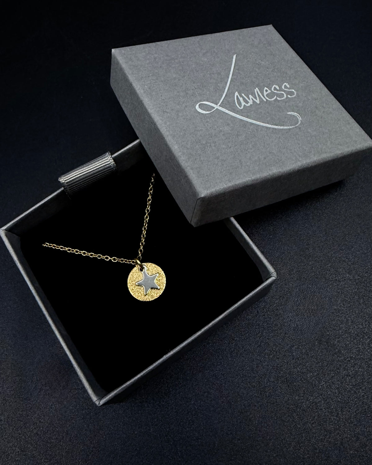 Gold and silver Urania Signal Star Necklace with textured gold disc and polished silver star charm on an adjustable stainless steel chain.