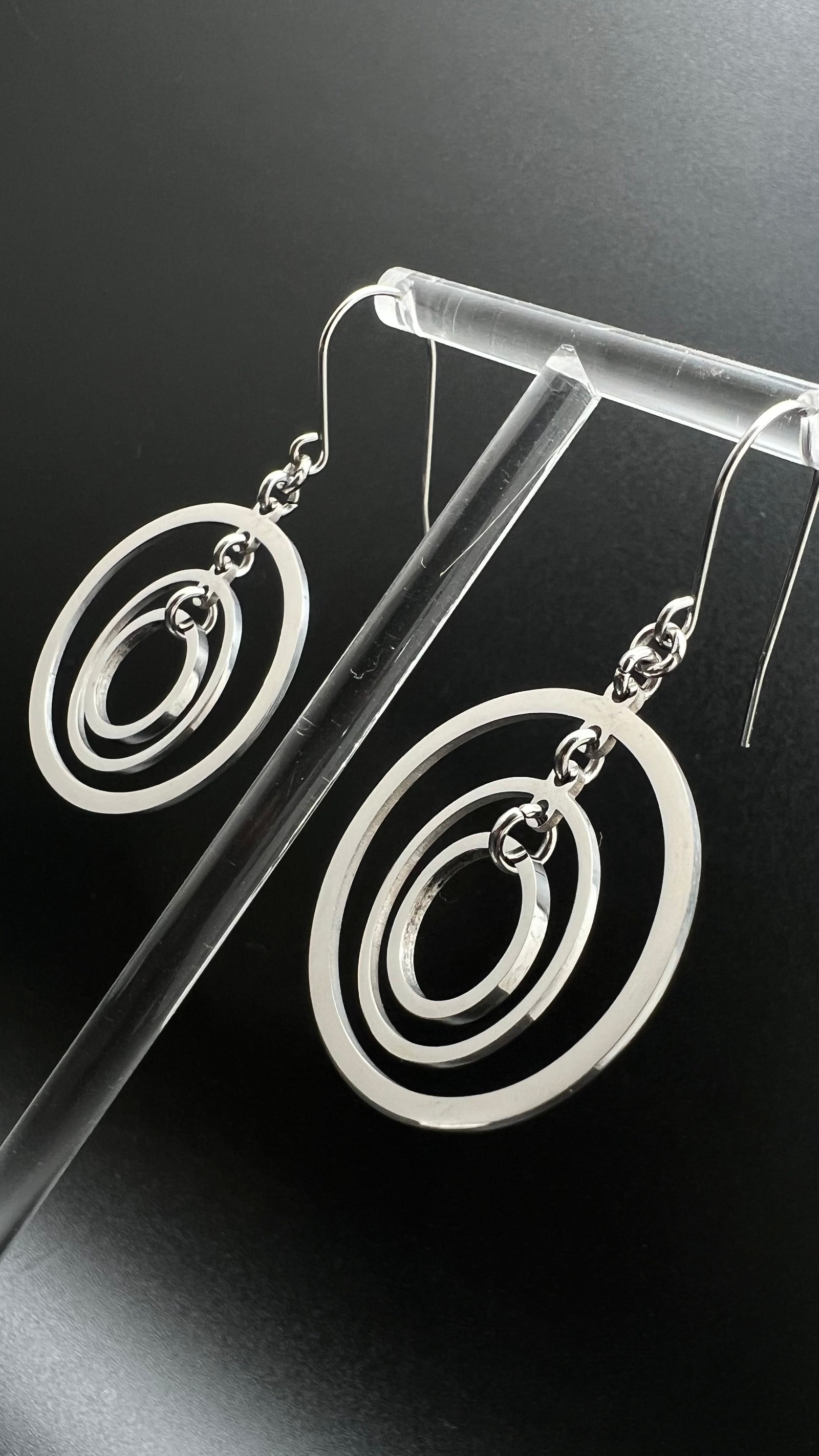Silver stainless steel triple-ring earrings with three interlinked high-polish rings and stainless steel hooks, 5 cm length — Lawless Jewellery.